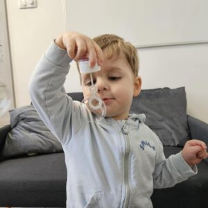 Chłopiec podczas terapii logopedycznej obserwuje bańkę mydlaną